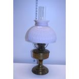 A antique brass oil lamp with opaque glass shade and chimney shipping unavailable