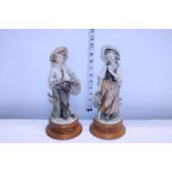 A pair of signed Nao figures on wooden bases