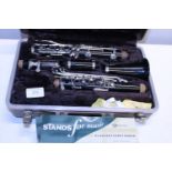 A cased Buescher clarinet (unchecked) with music stand,