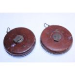 Two vintage leather cased tape measures, one with military marks