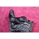A small hand carved coal figurine of a horse