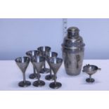 A vintage metal cocktail shaker and set of six glasses