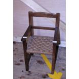 A small child's antique chair with woven seat. No postage