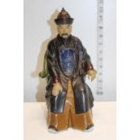 A ceramic figurine of a seated Chinese elder