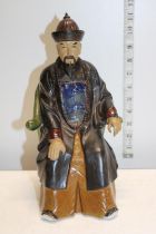 A ceramic figurine of a seated Chinese elder