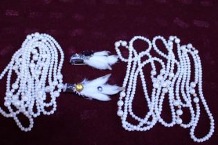 A selection of long simulated pearls and two Scottish themed brooches