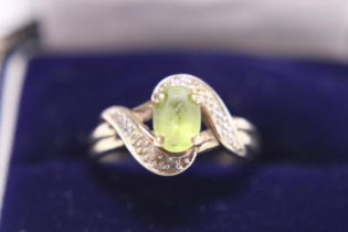 A vintage 9ct gold and green stone ring with diamonds to shoulders 2.26g. Size M.