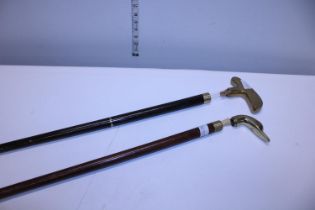 Two brass headed walking canes, one in the shape of a golf putter and one with a Ducks head with a