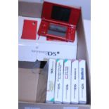 A Nintendo DS with charger and five games