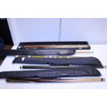 Four assorted snooker/pool cues