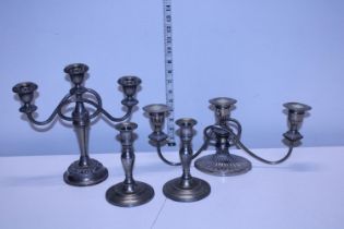 A pair of plated candlesticks and a two plated candelabra's