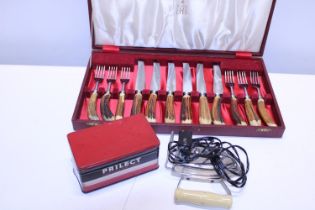 A set of vintage bone handled cutlery and a vintage travel iron