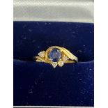 A quality 22ct gold ring with a central blue sapphire flanked by four brilliant cut diamonds. GW 3.