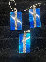 A silver earrings and matching pendant set