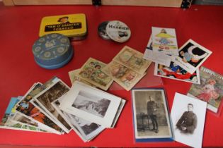 A selection of vintage tins and selection of vintage postcards