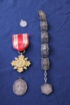 A selection of assorted medals and white metal items