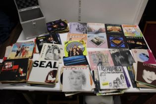 A selection of assorted mixed genre 7" singles and carry case