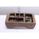 A antique Tibetan wooden spice box with contents of Oriental beads