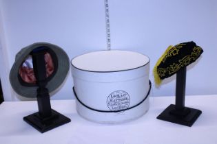 A hat box with wig stands and hats