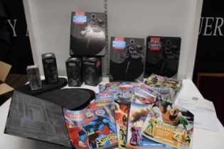 A selection of DC Comic items, including boxed figures, comics and stands
