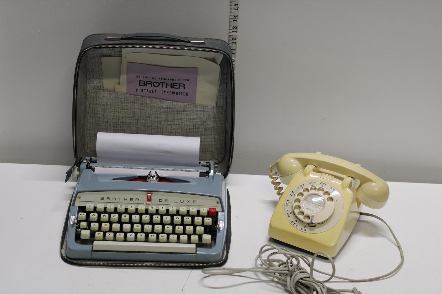 A vintage cased brother deluxe portable type writer and vintage telephone Shipping unavailable