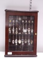 A job lot of collectors spoons in display case. Shipping unavailable