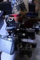 A selection of assorted vintage binoculars and cameras including Zeiss