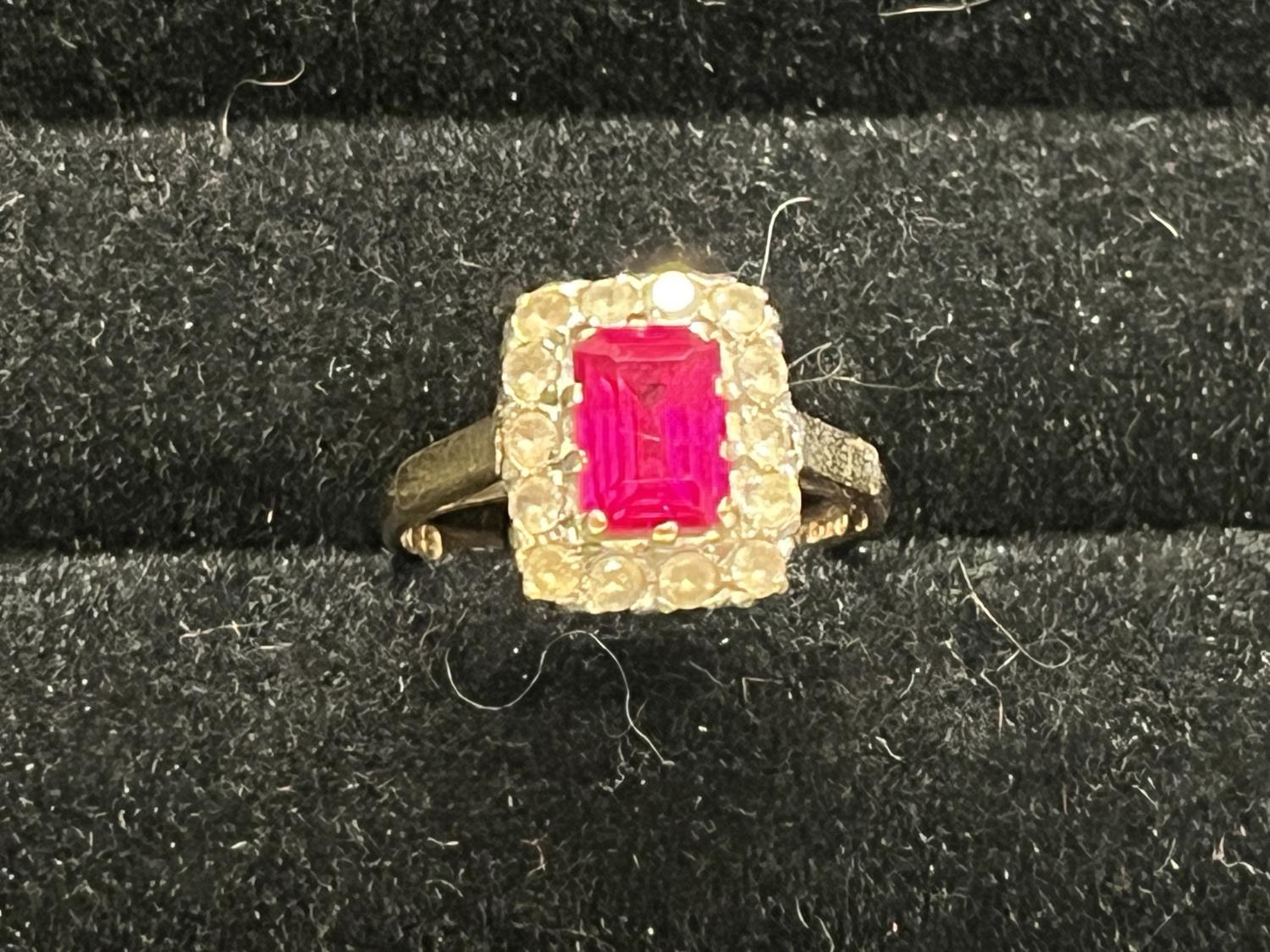 A 9ct gold ring with central pink sapphire and diamonds size M 2.76g
