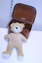 A small Steiff teddy bear in a suitcase