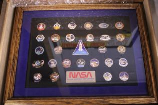 A framed NASA collection of enamel badges