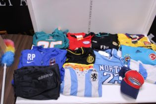 A box of assorted sports shirts and other