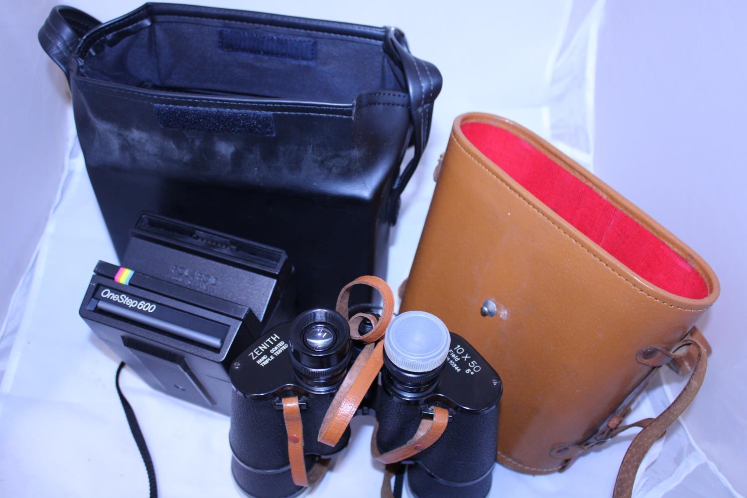 A pair of Zenith field binoculars and a vintage Polaroid camera