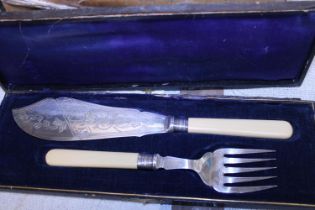 A cased fish and fork set with hallmarked silver collars