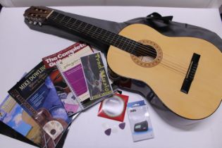 A cased Hohner acoustic guitar model MC-05, with a assorted guitar related books, strings and tuner,