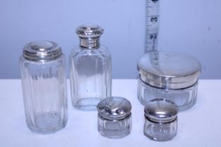 Five hallmarked silver topped glass bottles
