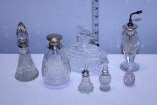 A selection of assorted silver topped perfume bottles and other glass bottles