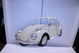 A tin plate wall hanging model of a VW beetle