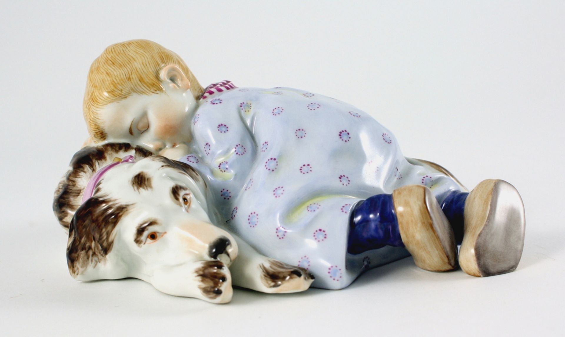 Hentschelkind. Polychrom staffierte Figurine. Kleines Mädchen schläft auf dem Rücken ihres Hundes.