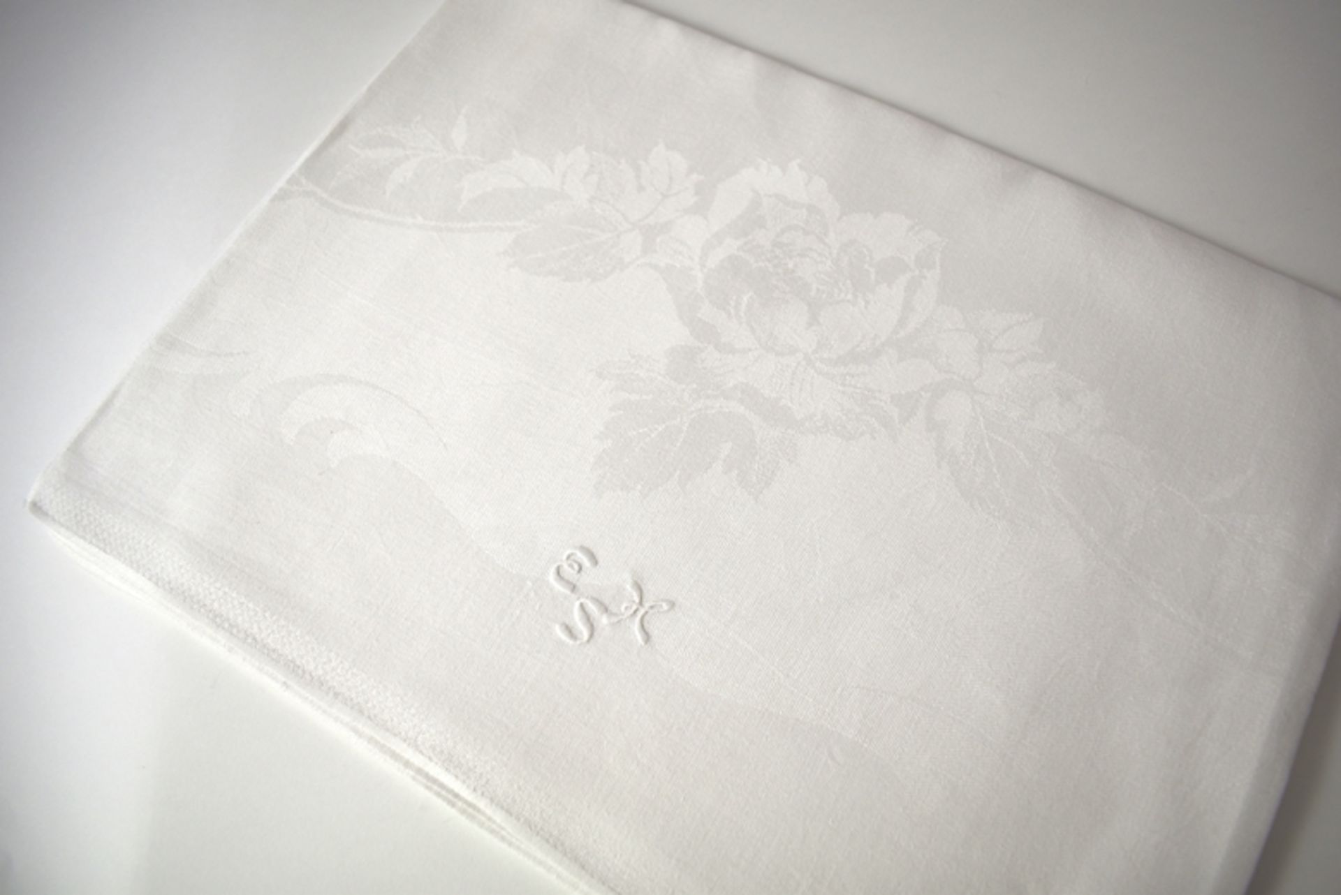 Quadratisches schwedisches Tischtuch mit Rosen und Monogramm "EHS". Feiner weißer Leinendamast. Ges