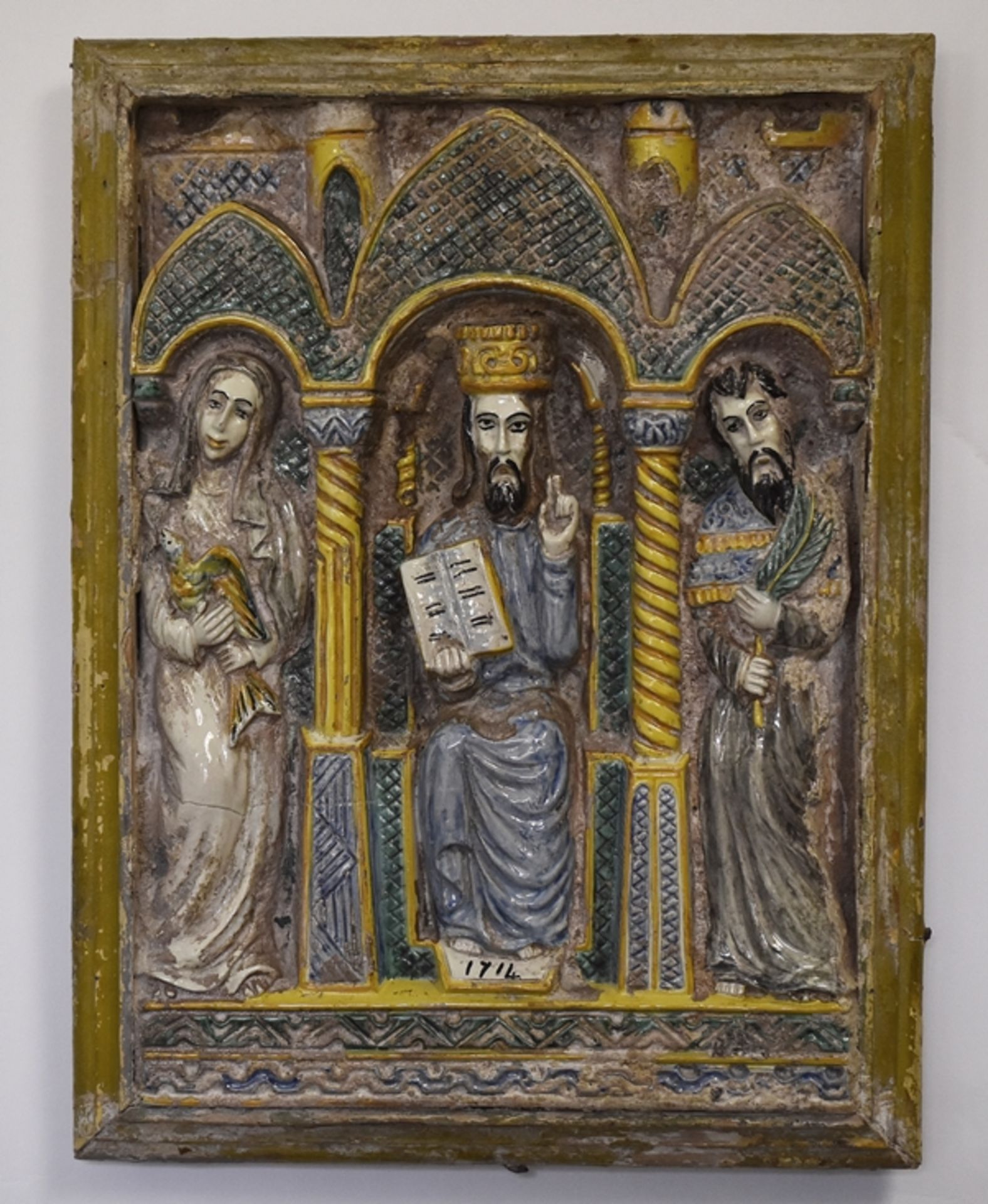 Ofenkachel. Relief mit Christus von Maria und Johannes flankiert. Polychrom glasierte Keramik. Rest
