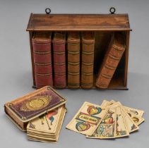 Kleiner Wandständer. Mit sechs Bücherhüllen für Kartenspiele, z.B. Ferd. Piatnik. 19. Jh. 14,5 x 21
