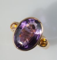 Großer Amethystring. Ovaler, facettierter Amethyst 11,26 ct. seitlich zwei runde facettierte Saphi