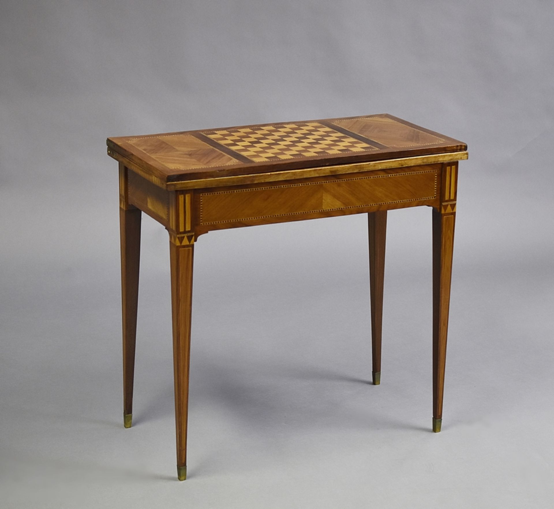 Louis XVI - Spieltisch. Auf hohen Vierkantspitzbeinen. Aufklappbare drehbare Platte, innen mit Filz
