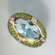 Turbanring. Mit blauem Topas und Tsavorithen in Pavéfassung, zus. 11,59 ct. dazu 0,12 ct. Brillante