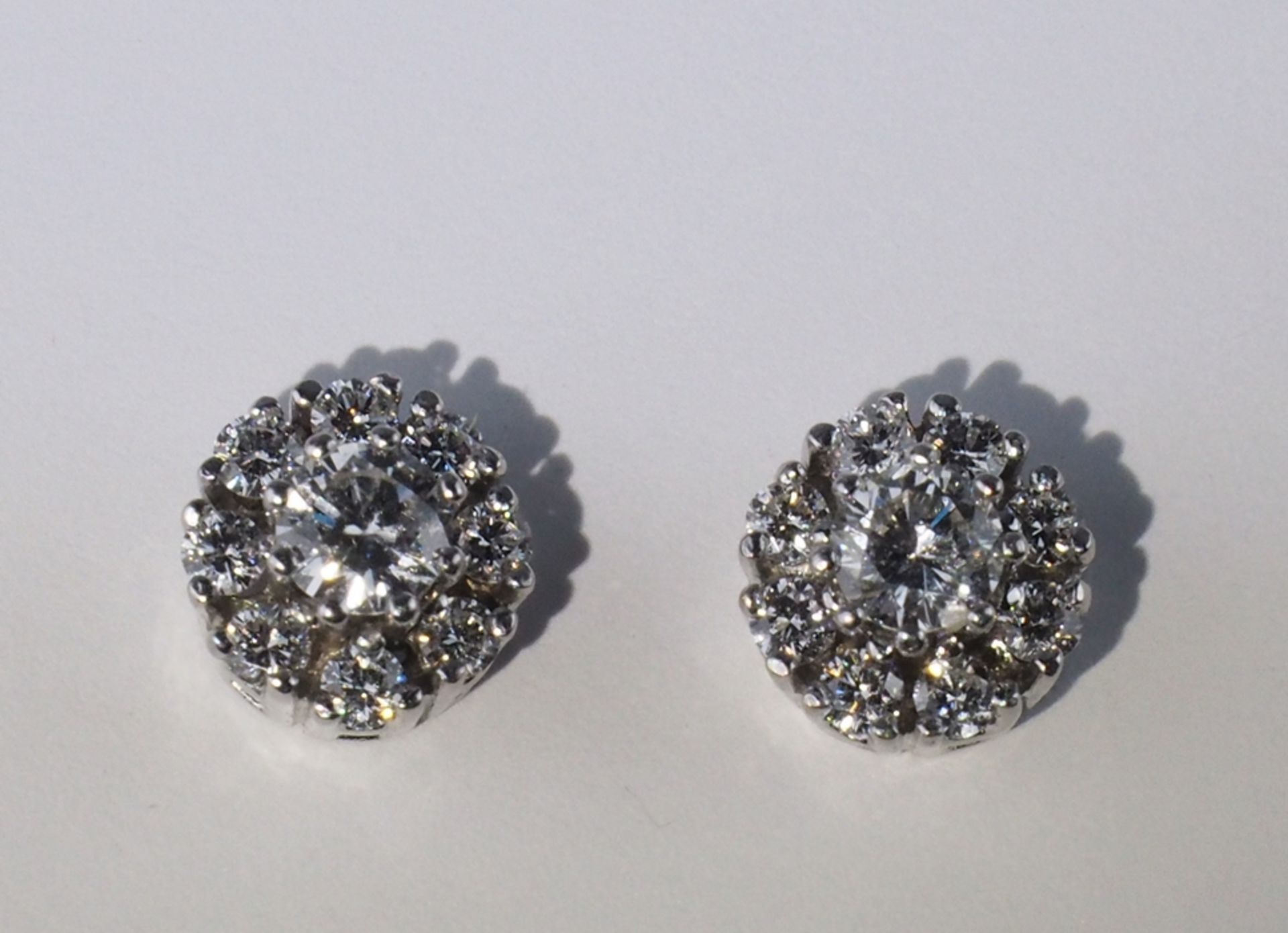 Paar Brillant-Ohrstecker.  Mittig Brillant ca. 0,15 ct. mit Brillanten karmosiert. 14 ct. WG