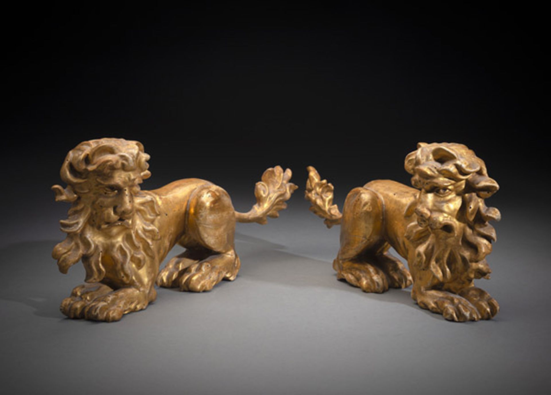 A PAIR OF RELIEF CARVED LION FIGURES