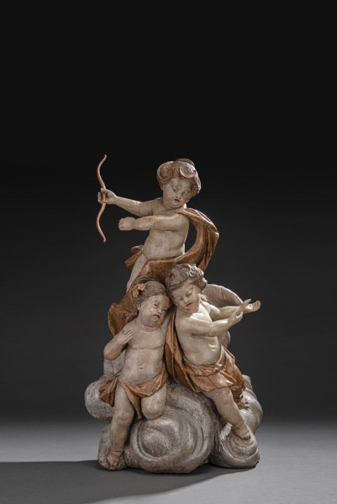 A LARGE ROCOCO GROUP OF CUPIDS ON A BAND OF CLOUDS