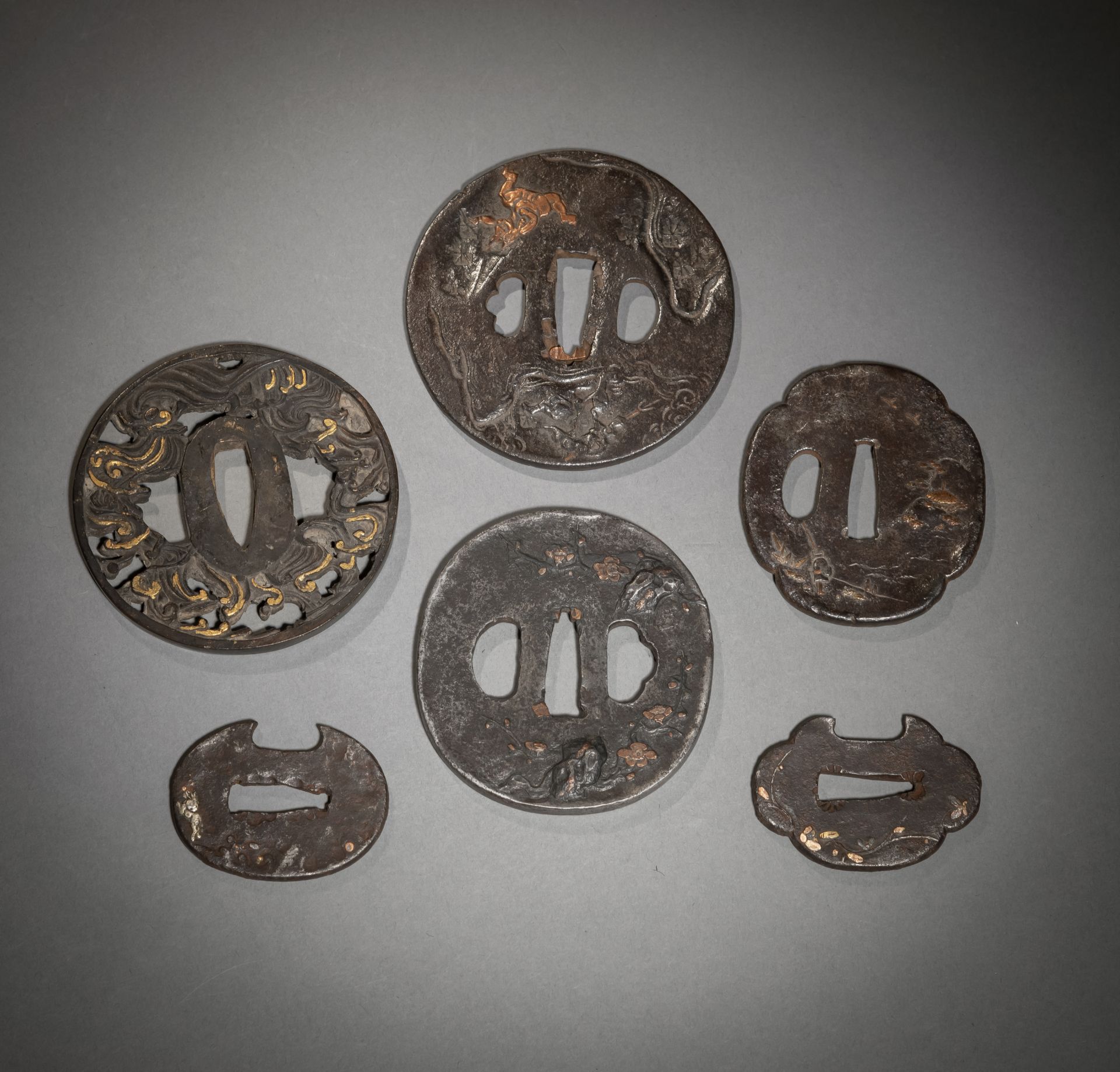 Sechs Tsuba aus Eisen mit eingelegten Reliefdekoren