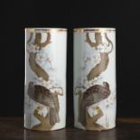 Paar zylindrische Porzellanvasen mit polychromem Dekor eines Raubvogels auf einem Ast