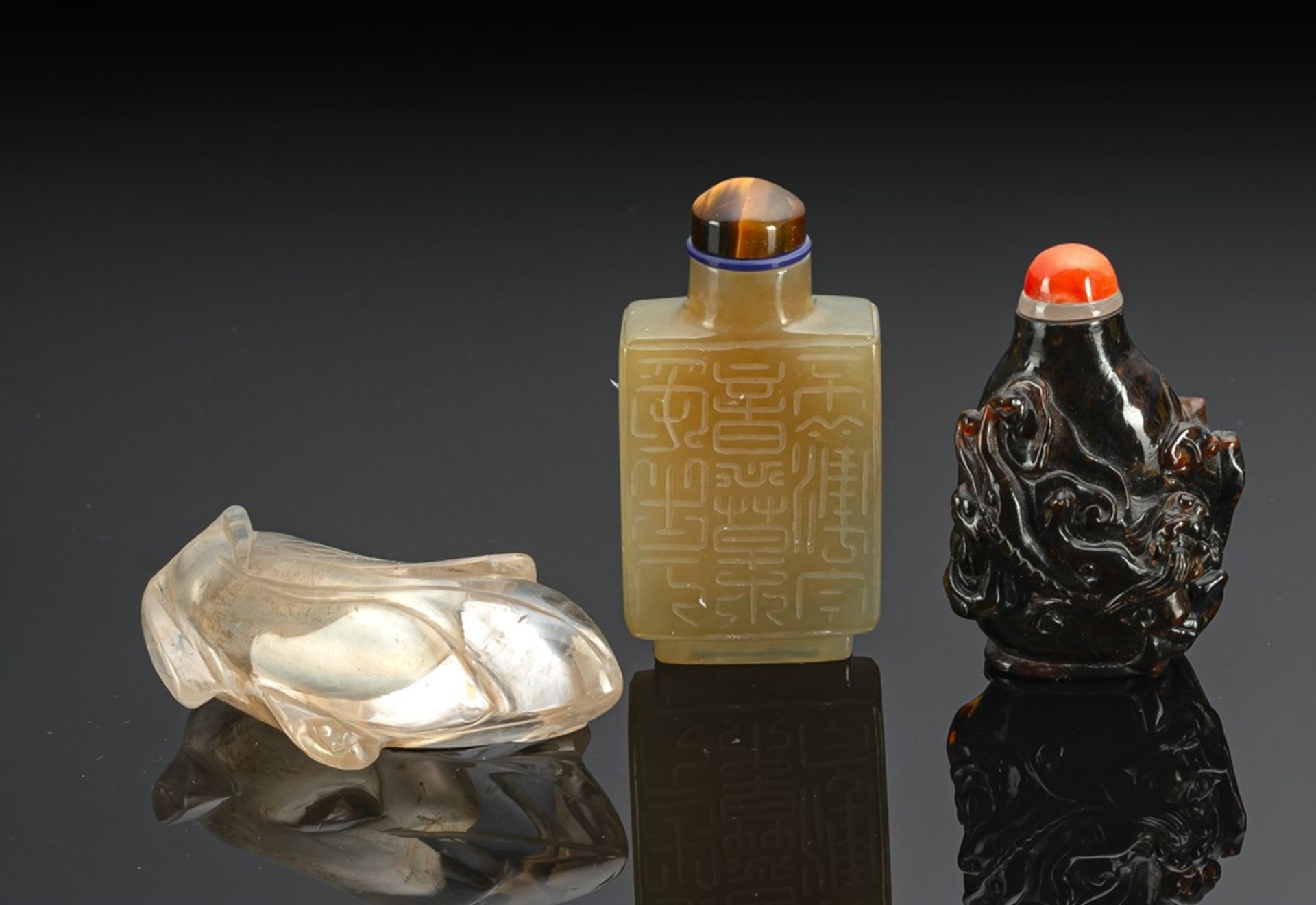 A GROUP OF THREE SNUFFBOTTLES: AMBER, AGATE AND ROCK CRYSTAL